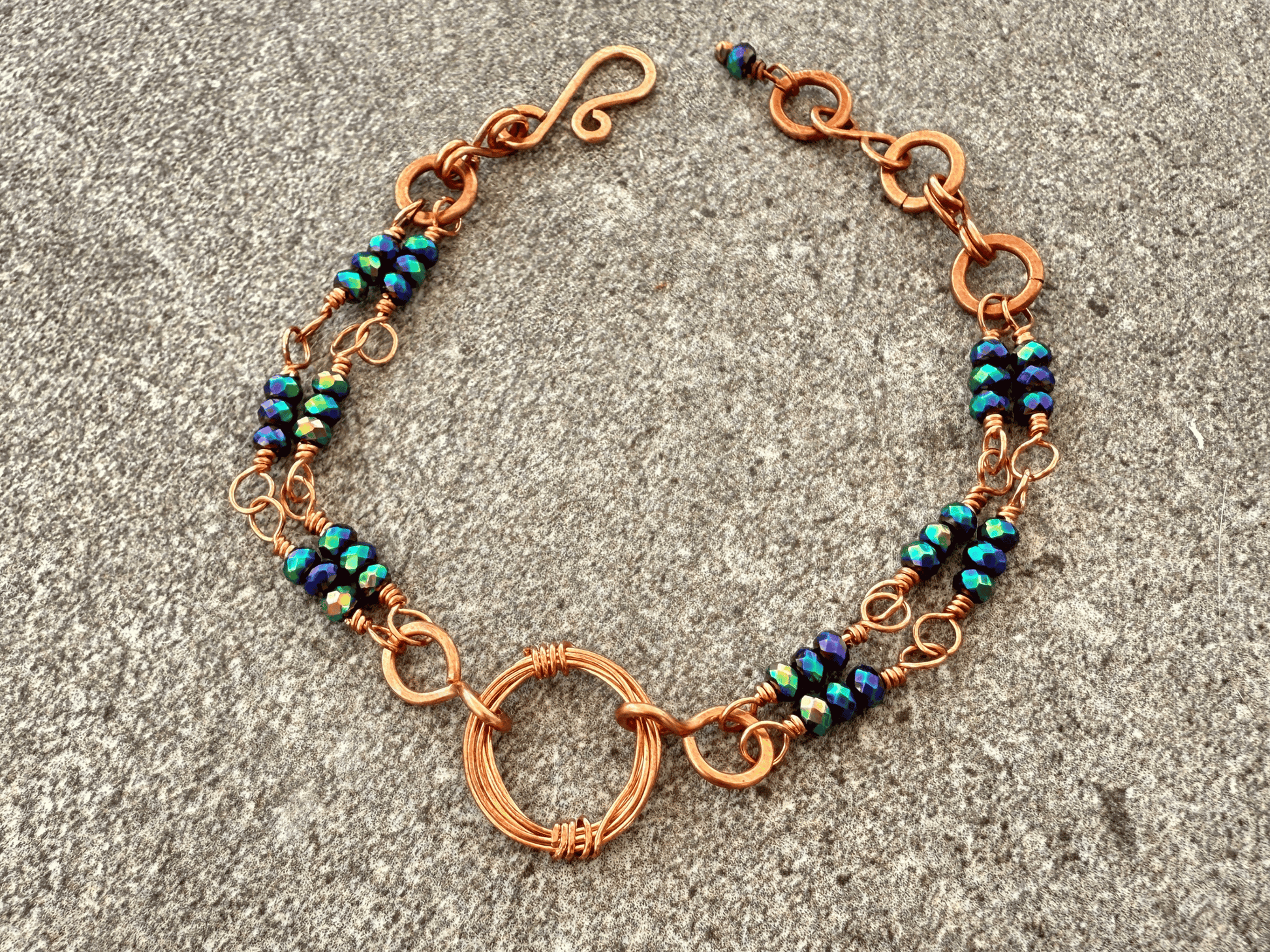 Crystal peacock crystal bracelet displayed on a slate background